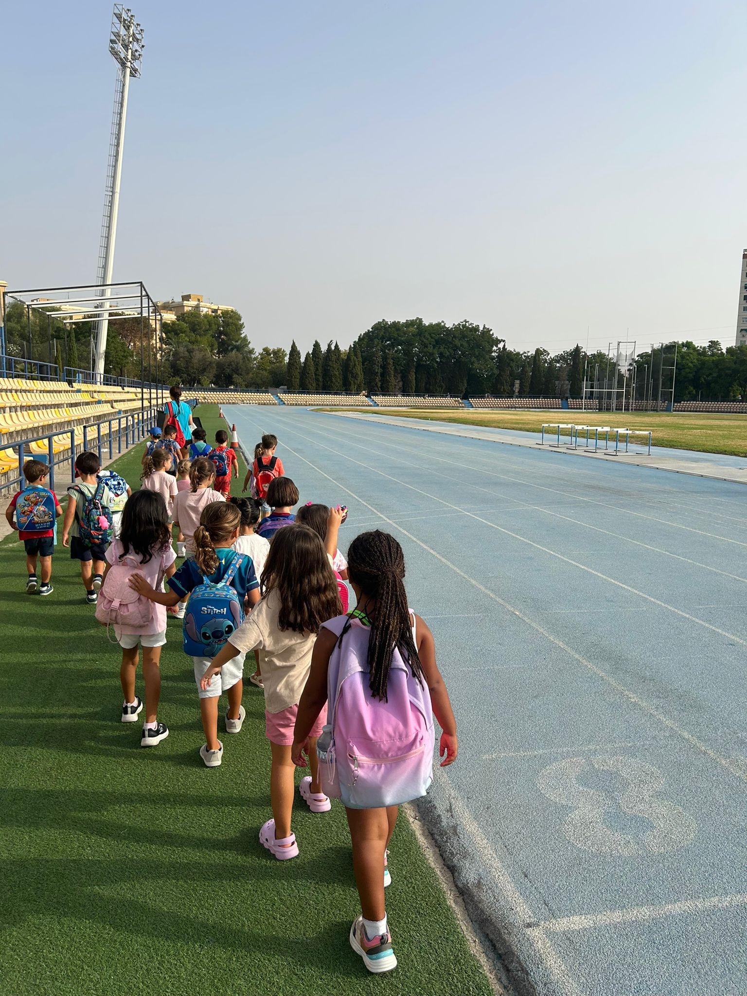 Niños caminando junto a la pista de atletismo durante el campus Atlantis